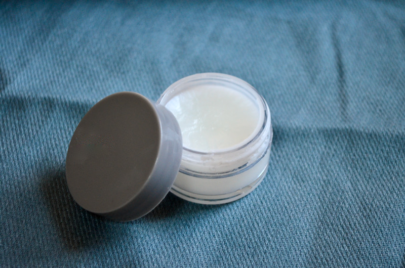 DIY face moisturizer in container on blue cloth