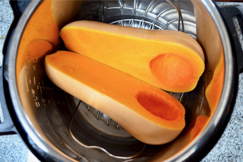 butternut squash sliced in half with seeds removed sitting in instant pot 