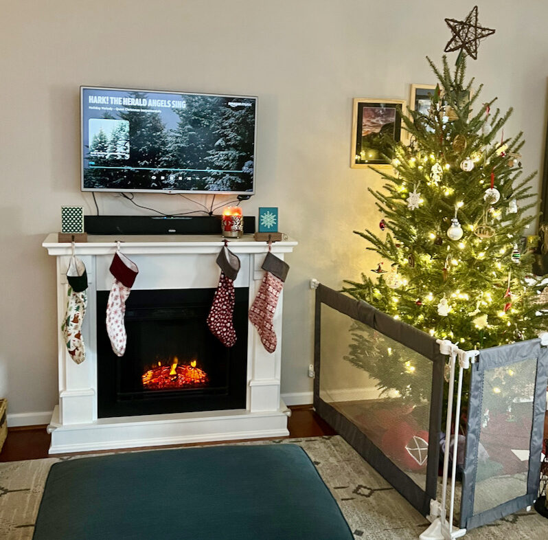 Christmas Stockings hanging on fireplace with baby gate and tree
