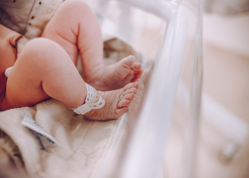 Newborn baby feet in hospital bassinet. 